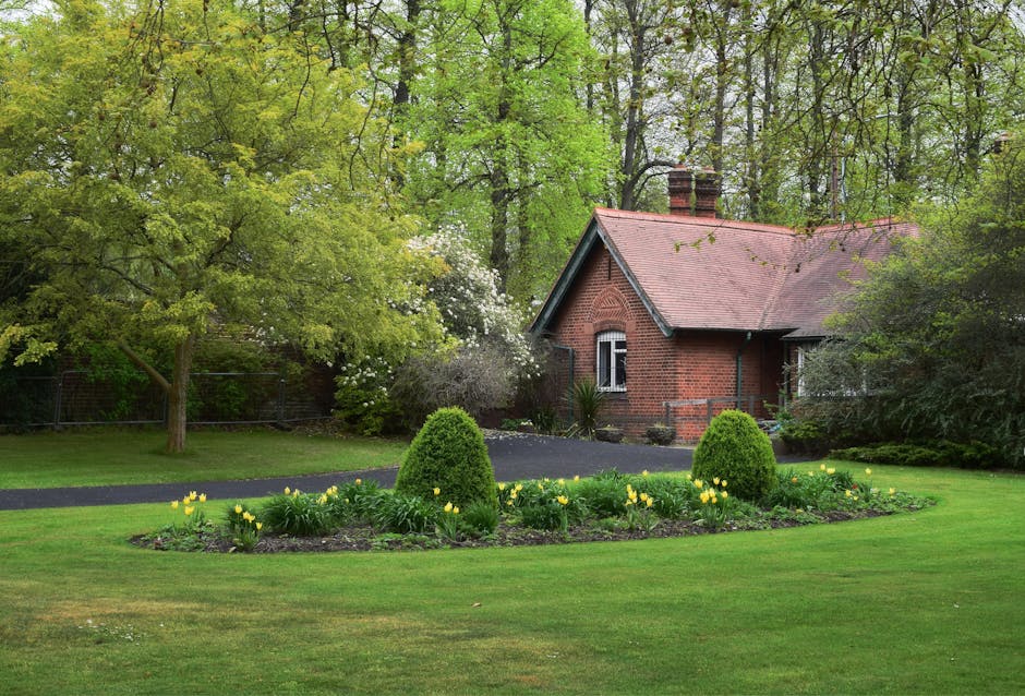 The image shows the front garden area of a traditional two-storey red brick house with a sloped slate roof, located on Blackfen Road. The garden features a small, well-maintained lawn bordered by a lo